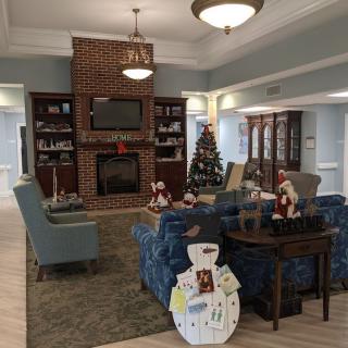 A cozy living room decorated for the holidays with a Christmas tree and fireplace.