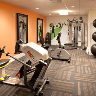 A modern gym with various exercise equipment and vibrant decor.