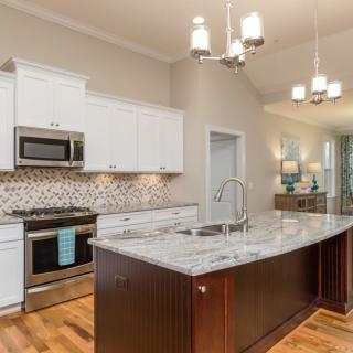 A modern kitchen with stainless steel appliances and a granite island countertop.