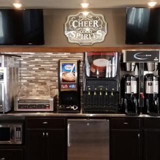 A self-service beverage station featuring coffee machines and drink dispensers in a restaurant setting.
