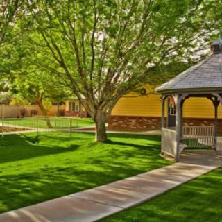 A serene outdoor park featuring a gazebo surrounded by lush greenery and well-maintained pathways.