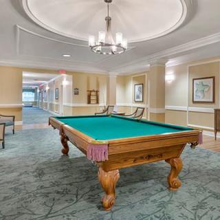 A well-lit game room featuring a pool table and elegant decor.