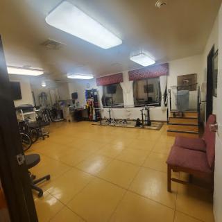 A spacious and well-lit gym area featuring various fitness equipment.