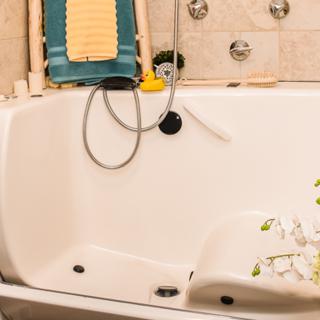 A cozy bathtub in a bathroom setting, complete with a showerhead and decorative elements.