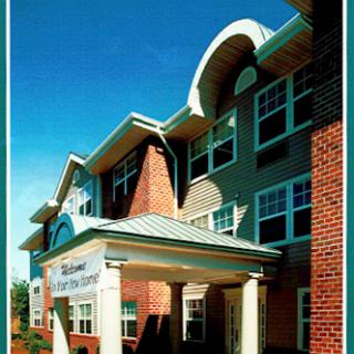 A well-designed residential building with a welcoming entrance under a clear blue sky.