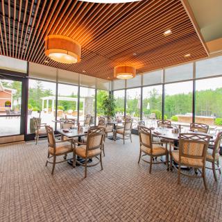 A modern restaurant dining area with large windows and ample natural light.