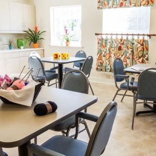 A bright and clean dining area with neatly arranged tables and chairs, adorned with colorful decor.
