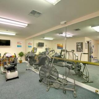 A small gym with exercise bikes and mirrored walls.