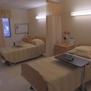 A hospital room with two beds and medical equipment.