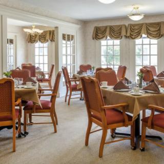 Elegant dining room with neatly arranged tables and natural lighting.