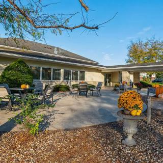 A spacious patio with outdoor seating and landscaping in front of a modern house.