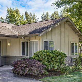 A suburban house with well-maintained landscaping and surrounding trees.