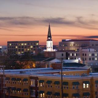 A picturesque city skyline at sunset, showcasing a prominent church steeple.