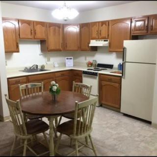 A cozy kitchen with wooden cabinets and a dining table.