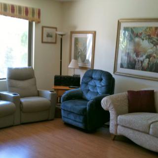 A cozy living room with comfortable seating and decorative artwork on the walls.