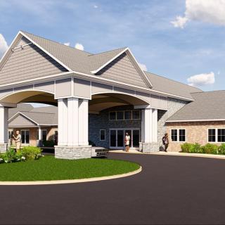 A modern building with a large archway entrance and landscaped surroundings.
