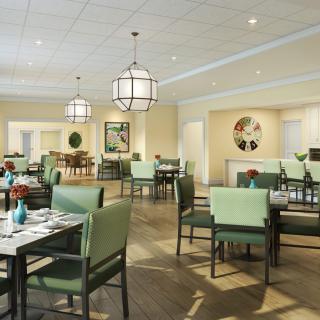 A modern dining room with elegant lighting and green seating arrangements.