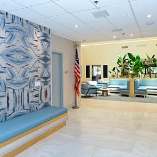 A modern waiting area featuring a stylish wall design, comfortable seating, and plants for a welcoming atmosphere.