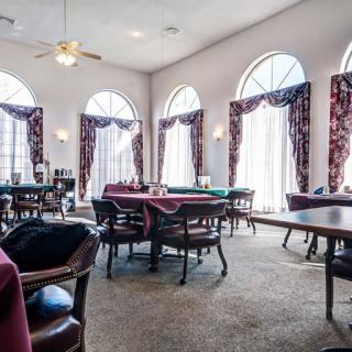 Spacious dining area with elegant tables and chairs, featuring large windows and decorative curtains.