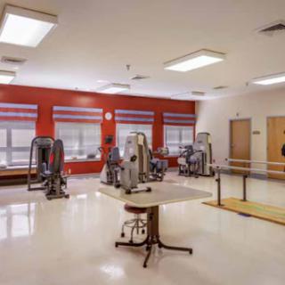 A well-equipped physical therapy room featuring exercise machines and a spacious layout.