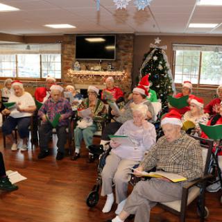 Seniors gather for a joyful holiday sing-along, celebrating the season with music and cheer.