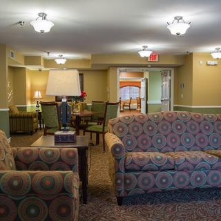 A cozy lobby area featuring patterned sofas and armchairs with soft lighting.