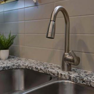 Modern kitchen sink with a sleek faucet and granite countertop.