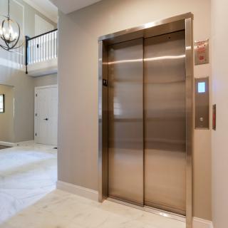 A modern elevator located in the hallway of a residential building.