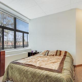 A cozy bedroom with a comfortable bed and large window.