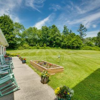 A spacious backyard with a vibrant lawn, patio, and garden under a clear blue sky.