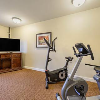 A small home exercise room featuring stationary bikes and a television.