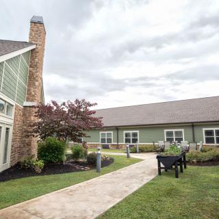 A peaceful garden setting with a modern building and pathway.