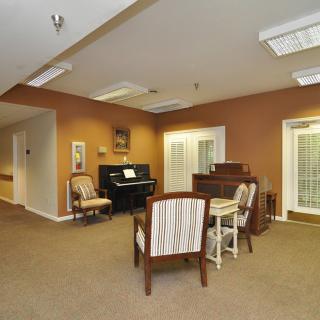 A cozy room with a piano and comfortable seating area.