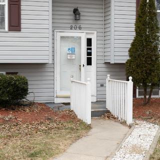A welcoming entrance to a home with a clear pathway and simple landscaping.