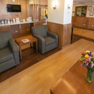 A comfortable hotel lobby with seating area and floral arrangement.