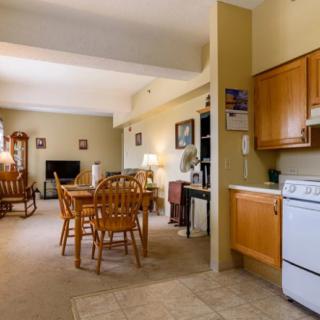 A cozy living space featuring a dining table, kitchen area, and comfortable seating.