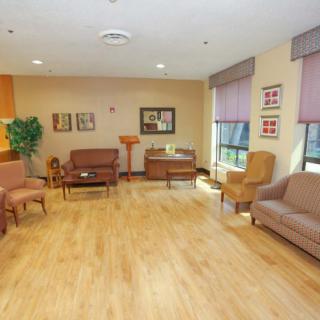 A cozy living room with comfortable seating and wooden flooring, adorned with various decorations.