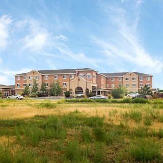 A large hotel building set against a blue sky with grassy foreground.