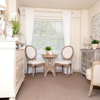 A well-lit, elegantly decorated interior with a small table and two chairs by the window.