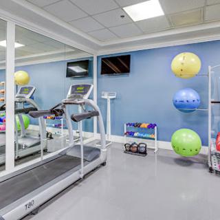 A well-equipped gym area featuring a treadmill and exercise balls.