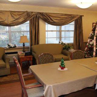 A cozy living room decorated for the holidays, featuring comfortable seating and a festive Christmas tree.