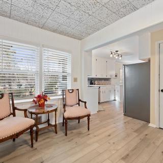 A cozy living area with elegant chairs, a small table, and large windows letting in natural light.