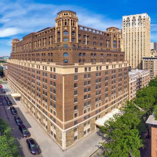 A historic urban building with intricate architecture dominates the city street.