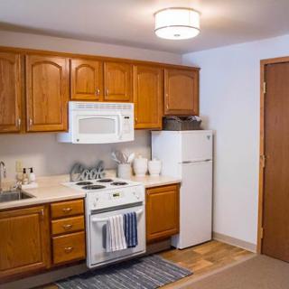 A cozy kitchen featuring wooden cabinets and essential appliances.