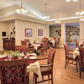 A cozy dining room with elegantly set tables and warm lighting.