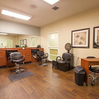 An interior view of a barbershop with chairs and mirrors.