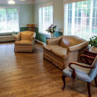 A well-lit living room featuring comfortable seating and a wooden floor.