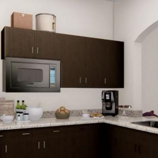 A modern kitchen with dark cabinets, featuring a microwave and coffee maker on the countertop.