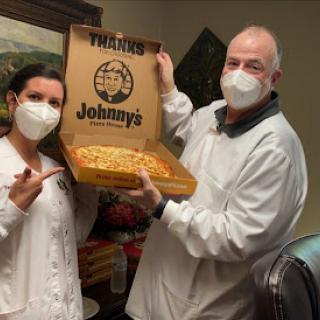 Sharing a delicious pizza from Johnny's with smiles and masks!