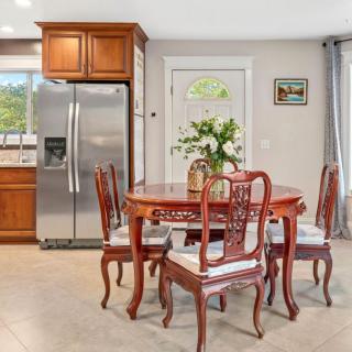 A cozy kitchen area with a wooden dining table and chairs, complemented by a floral arrangement.